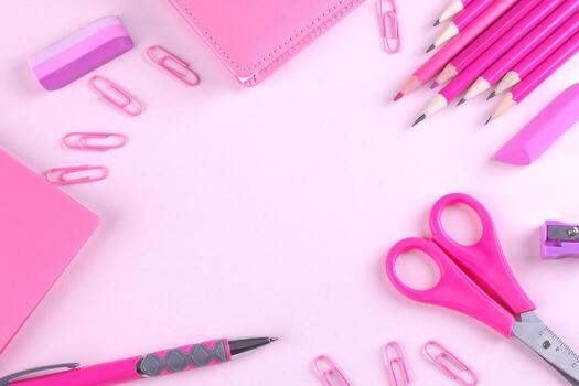 Various stationery in one color scheme on a bright paper pink background. Top view photo