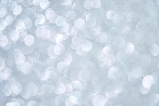 Abstract silver bokeh lights on soft gray background with circular blurred patterns. photo