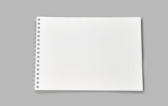 Blank spiral notebook on gray background with open white pages for sketching or writing. photo