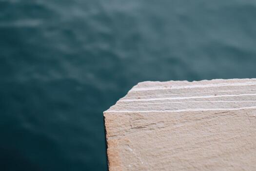 Calm waters meet rugged stone edge at serene waterfront location photo