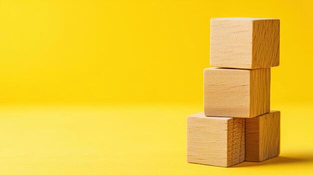Wooden blocks stacked on a bright yellow background create a playful arrangement photo