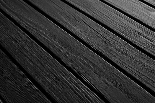 Dark wooden planks arranged in a parallel pattern on a surface photo