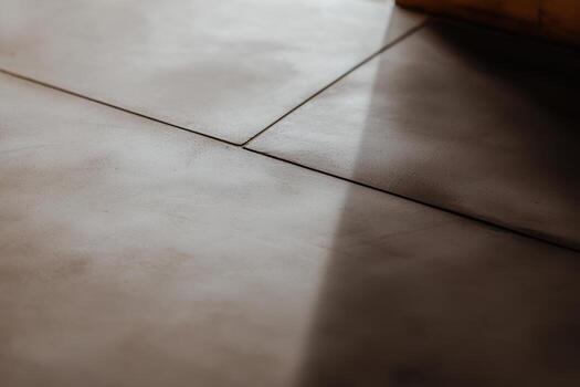 Close-up view of textured floor tiles with shadows in natural light photo
