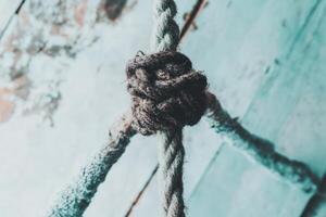 Rope knot on weathered turquoise wood in a tranquil outdoor setting photo