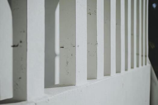 Unique architectural design of a minimalist white fence in bright sunlight photo