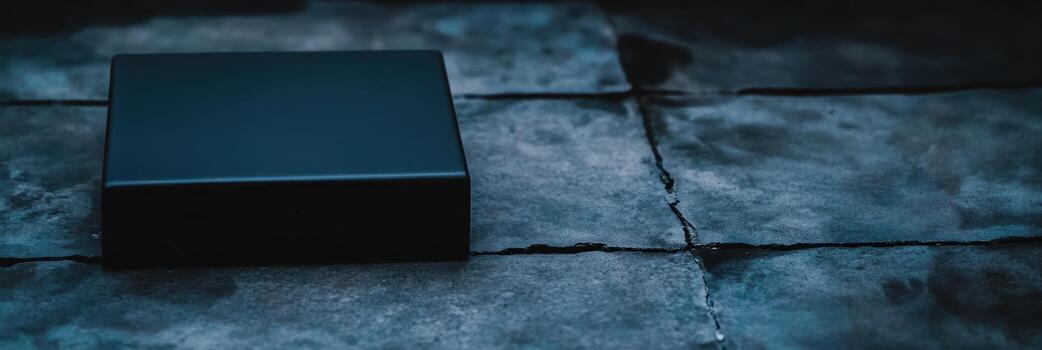 Mysterious black box on weathered stone tiles in dim lighting photo