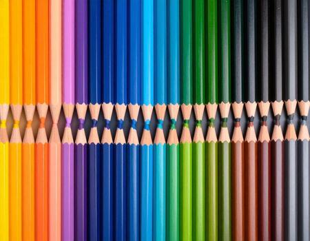 Vibrant flatlay featuring spectrum of colored pencils arranged in rainbow pattern, showcasing their sharpened tips. colorful display evokes creativity and artistic expression photo