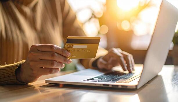 en línea compras concepto con persona participación crédito tarjeta y utilizando ordenador portátil computadora en calentar luz de sol foto