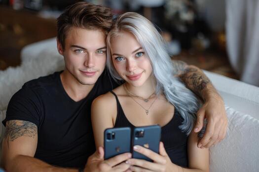 Young couple sharing a joyful moment while using smartphones at home in a cozy setting photo