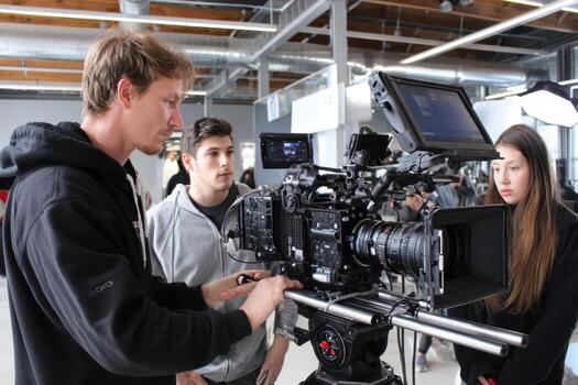 Students learning film production techniques in an editing studio during a workshop photo