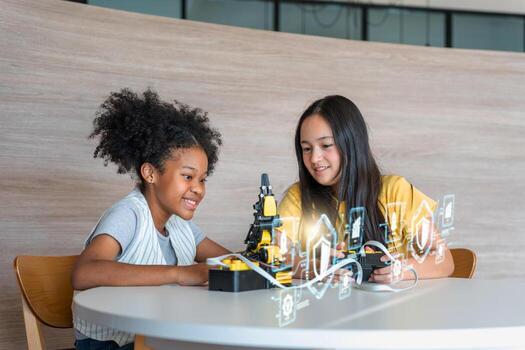 Diverse Kids Building a Robot Arm in a Science Workshop, Young Girls Engaged in Robotics and STEM Learning, Two Girls Exploring Technology and Innovation photo