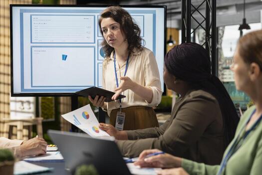 Collaborative team of professional women reviews key data and reports while setting strategy for business growth, aligning insights with development goals and teamwork. Networking. photo