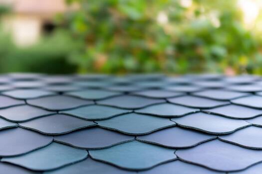 Abstract pattern texture of overlapping scales or roof shingles with blurred greenery background photo