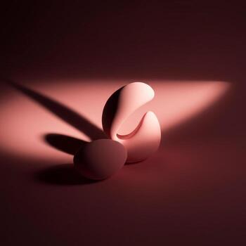 A pink egg on a red surface with a light shining on it photo