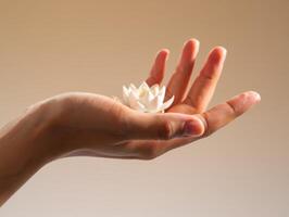 delicado blanco flor descansa suavemente en un abierto humano mano foto