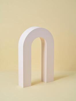 Minimalist archway sculpture on a soft yellow background photo