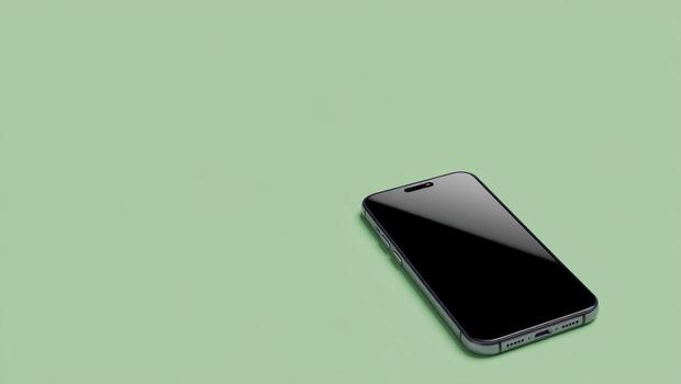 Modern black smartphone lying on a light green background with copy space photo