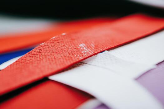 Colorful strips of tape layered together in close-up view on a surface photo