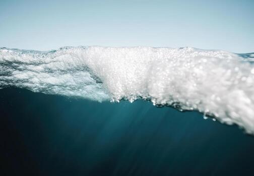 Ocean wave cresting under bright sky during calm daytime photo