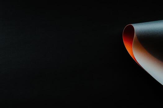 Vibrant paper curl in dark setting showcases texture and color contrast photo