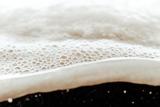 Close-up view of frothy liquid bubbles in a dark setting during evening time photo
