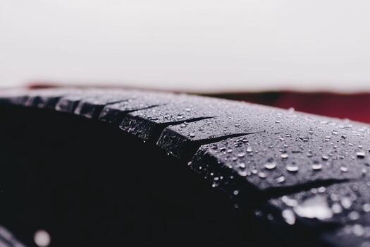 Close-up of a wet tire showing tread patterns in rainy weather photo