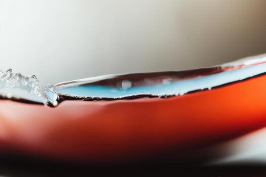 Close-up of liquid splashing from a red object in soft light photo