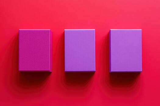 Three purple boxes arranged on a vibrant red surface during daylight photo