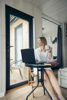 Creating Calm and Focused Home Office Environment, woman with a laptop at a table photo