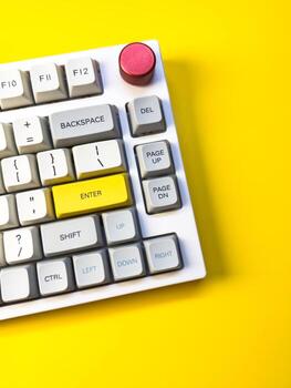 keyboard bright Enter key on bright yellow background, minimalism, keyboard buttons. A keyboard with a yellow key on the bottom left photo