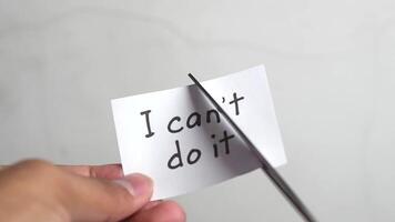 Man using scissors to remove the word can't to read I can do it concept for self belief, positive attitude and motivation video