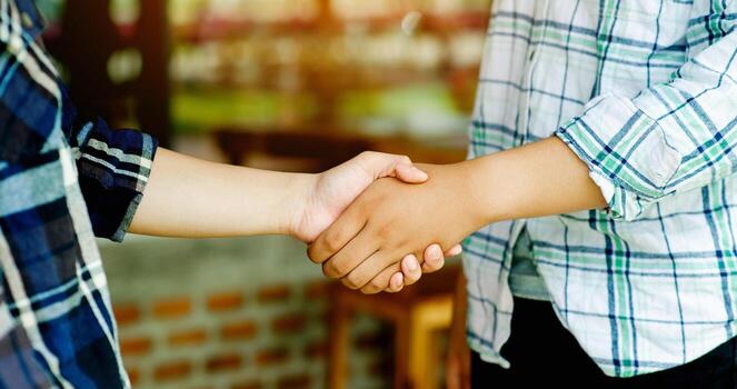 Handshake. Close-up of two young gardeners. Discussing and sharing work secrets Agricultural work and work to be successful A gentle closeness shows support and understanding. photo