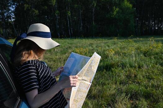 The photo highlights the act of exploration and wayfinding as a woman studies a map in an outdoor setting.