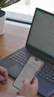 un' persona utilizzando un' smartphone per Scrivi un' testo Messaggio su un' il computer portatile video