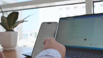 man använder sig av smartphone till skriva en text meddelande på bärbar dator video