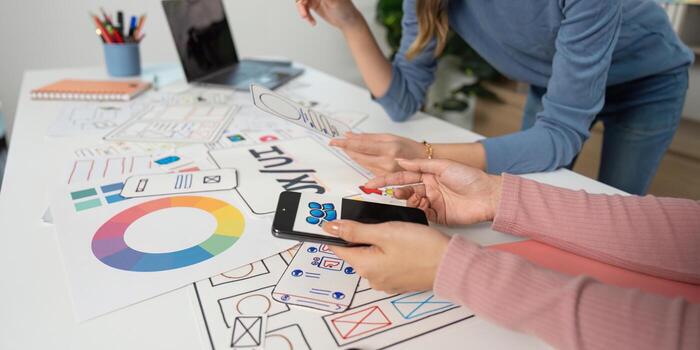 UX and UI Design Process. Designers analyzing mobile app prototypes and sketches. photo