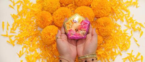 diwali ritual. vistoso diya retenida encima maravilla flores para festivo celebracion. foto