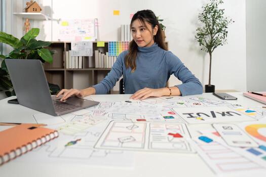 UX and UI Designer at Work. Female professional creating digital wireframes in a collaborative environment. photo