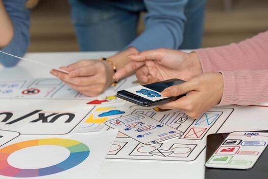 UX and UI Design Team Collaborating with Sketches and Smartphone photo