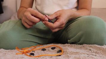 Engaged in a fun activity, a woman uses colorful magnets to create different shapes and designs. She enjoys experimenting with various combinations and placements on a plush surface video