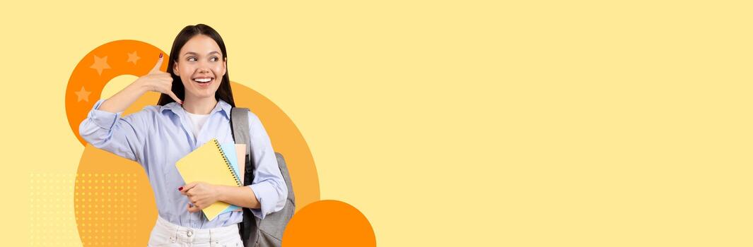 A joyful student stands with notebooks and a backpack, showing call me gesture, looking at copy space. She poses confidently with a cheerful expression on a vibrant, sunny background. photo