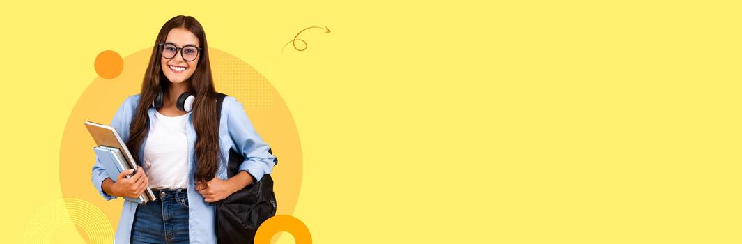 A student is smiling while holding an array of study materials and a backpack in a bright, modern educational setting. The cheerful atmosphere encourages learning and growth. photo