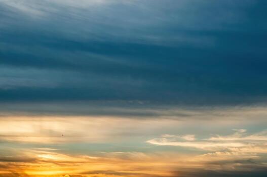 Scenic view of a vibrant sky at sunset featuring a gradient of colors from dark blue to golden hues, creating a serene and picturesque atmosphere, ideal for backgrounds and designs. photo