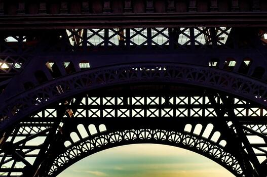 Detailed view of the eiffel tower ironwork against the sky in paris, france. The architectural details and structural design showcase the iconic landmark engineering. photo