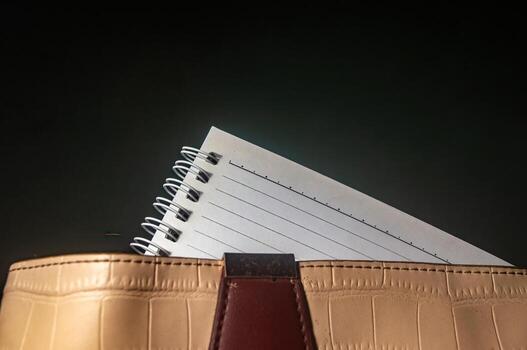 Close up of a handbag with a notebook, offering a simple and functional image. Ideal for themes related to organization, planning, or everyday essentials in a minimalist style photo