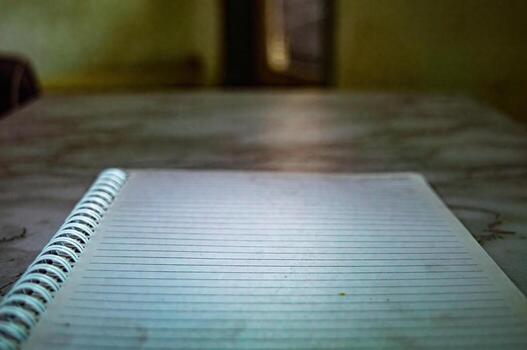 Close up of a spiral notebook with lined paper on a table, showing a simple and functional design for writing, journaling, or note taking in a home or office setting photo