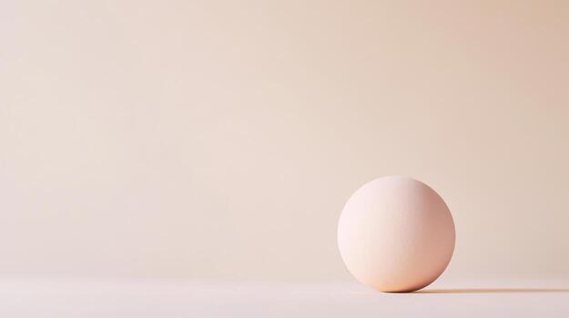 A single smooth sphere featuring a gentle gradient rests on a surface, illuminated by soft light, creating a tranquil and modern atmosphere photo