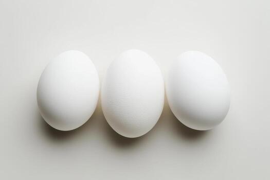 White eggs arranged in a row on a plain background during daylight photo