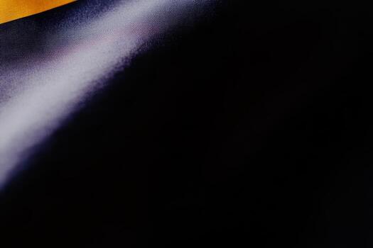 Fabric texture showcasing smooth gradients of black and gold tones photo