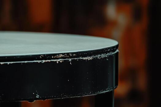 Circular black table with worn edges in warm indoor setting photo